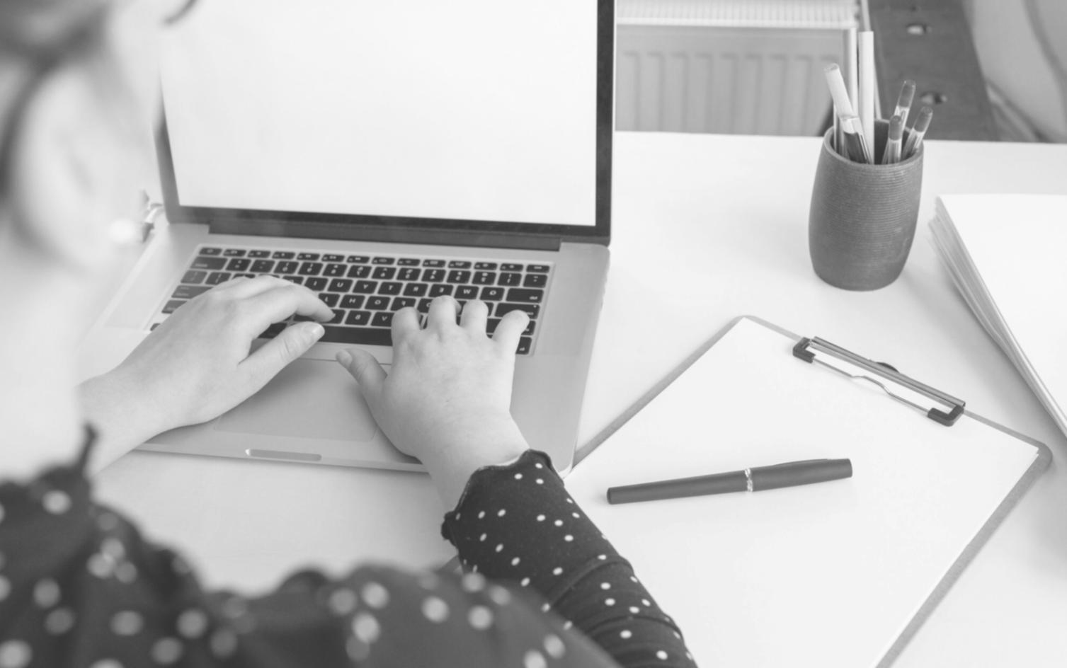 Financial professional reviewing investment reports on laptop during remote learning session